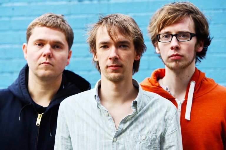 banda GoGo Penguin posa para foto em fundo azul