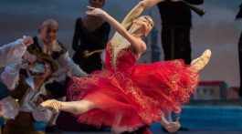 Bailarina Oksana Bondareva de vestido vermelho se apresenta