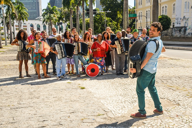 Orquestra Sanfônica ri para fotografia em dia ensolarado